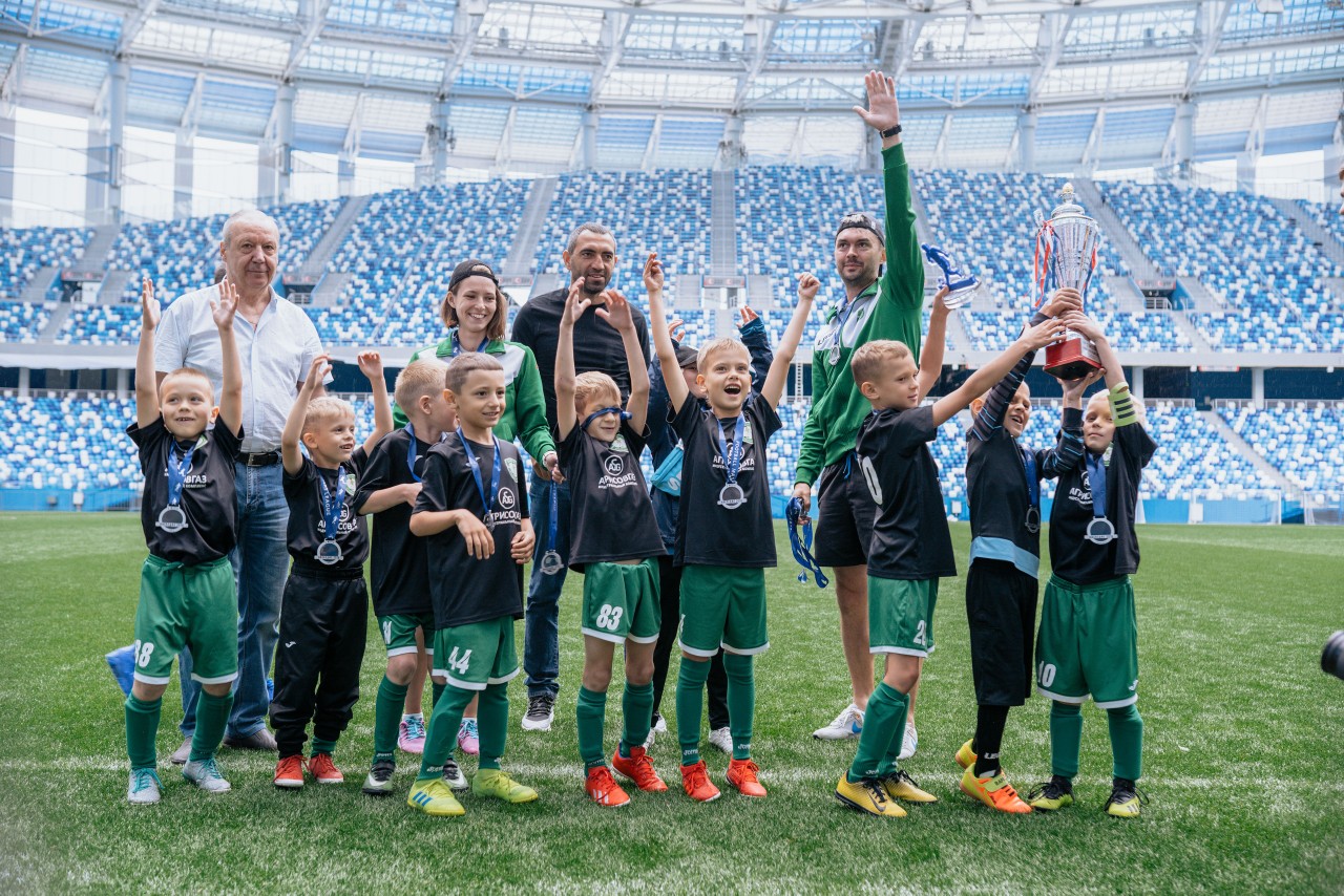 Дети играют в футбол на стадионе